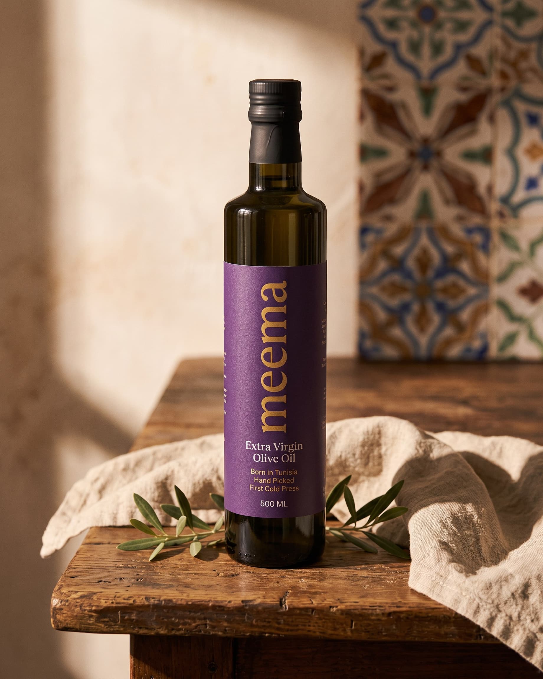 The Meema 500ml bottle on a wooden table against patterned tiles